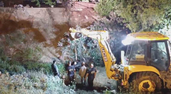 Düştüğü su kanalında çamura saplanan inek, kepçeyle kurtarıldı